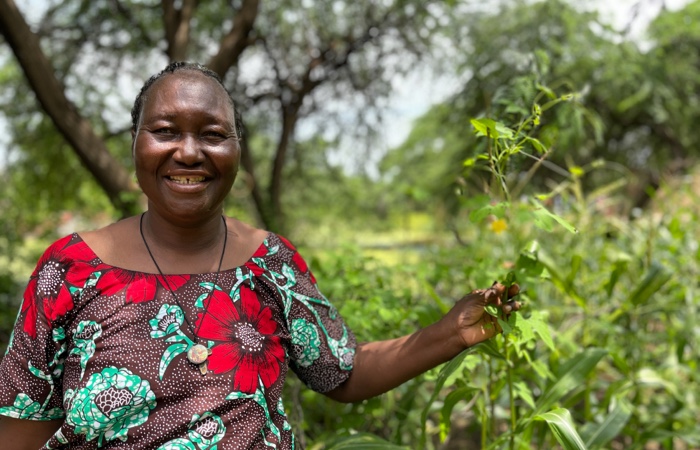 Woman smiling holding onto vegetation.