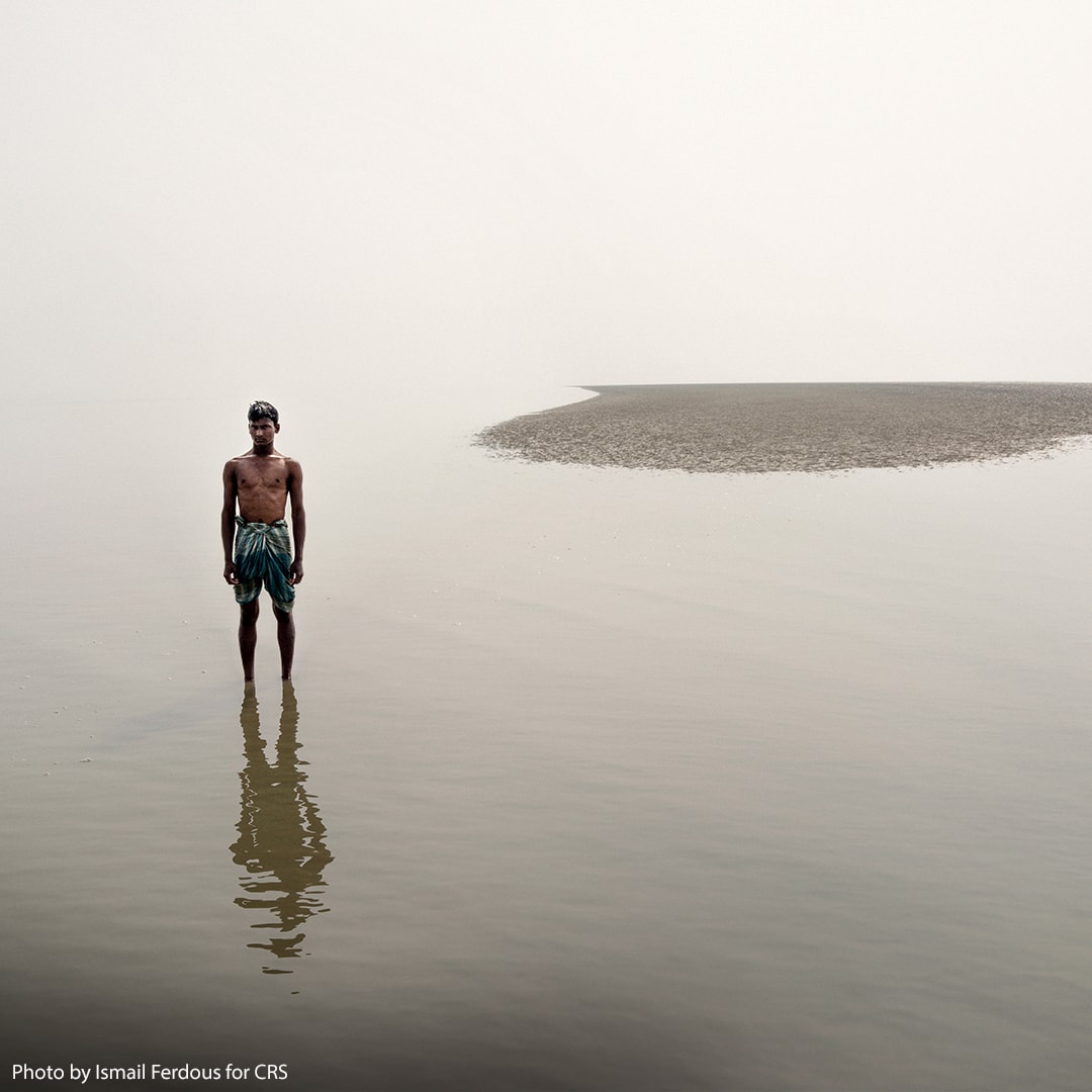 Man stands on land where lake normally stood.