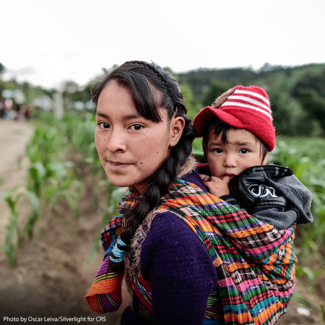 Mother carrying child on her back.