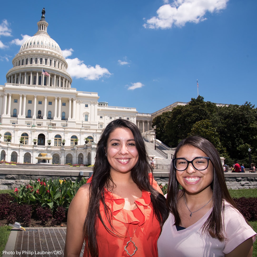 Two women pose together in front of Congress building.