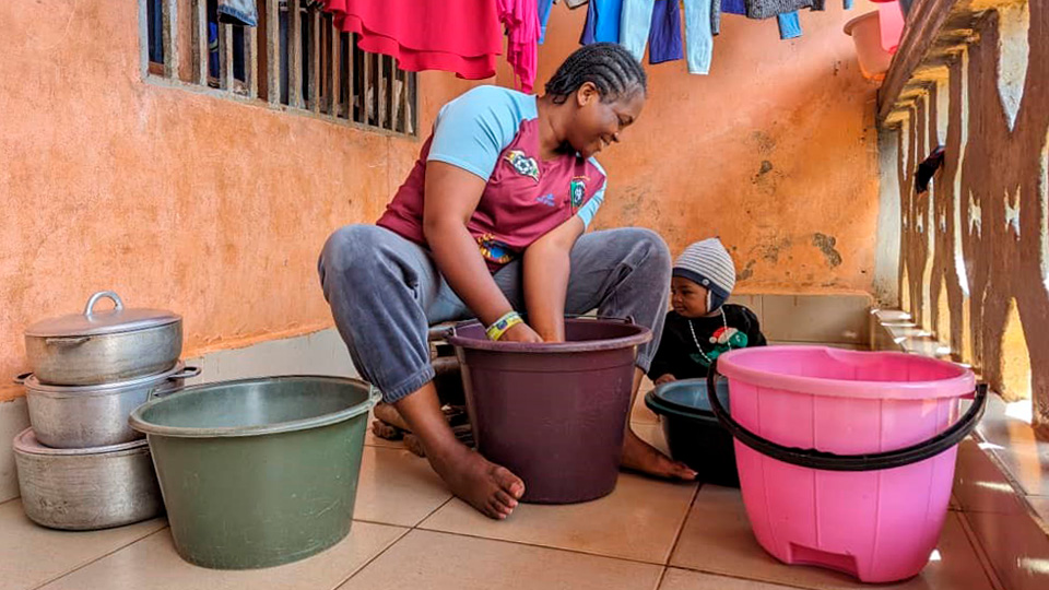 Woman and child sitting around buckets.