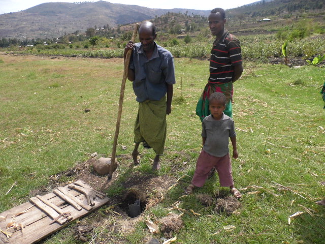 Abdi Mohamed (with pole) stands by his well with his sons. Photo by Bedil Derese for CRS