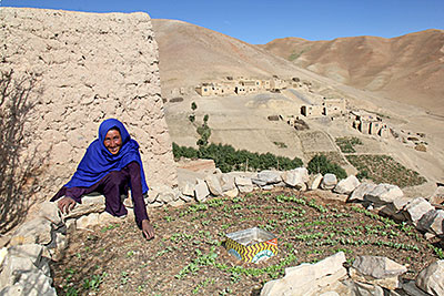 Bonu, a mother of three from Afghanistan's Ghor province, weeds her new keyhole garden. She looks forward to her first harvest and the nutritious meals she will prepare with recipes from Catholic Relief Services. Photo by Jennifer Hardy/CRS