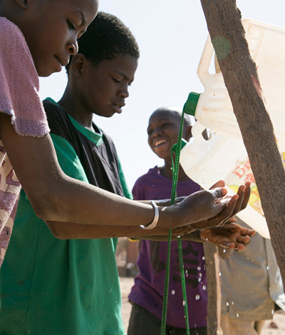 Students use a "tippy tap" to wash their hands at a school in Burkina Faso. Photo by Michael Stulman/CRS