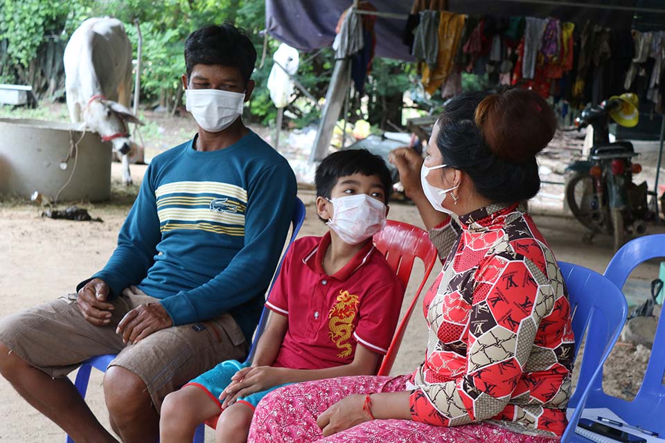 child with family wearing masks in Cambodia