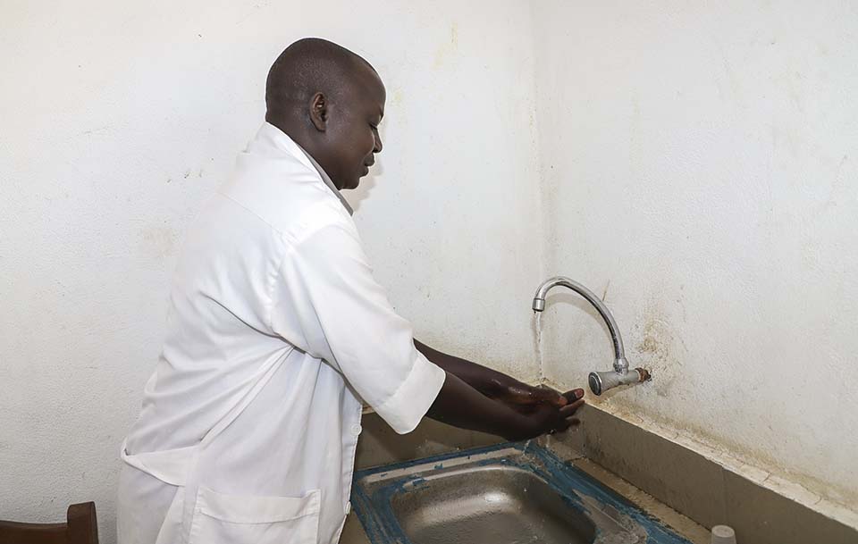 Cameroon health workers washes hands at sink