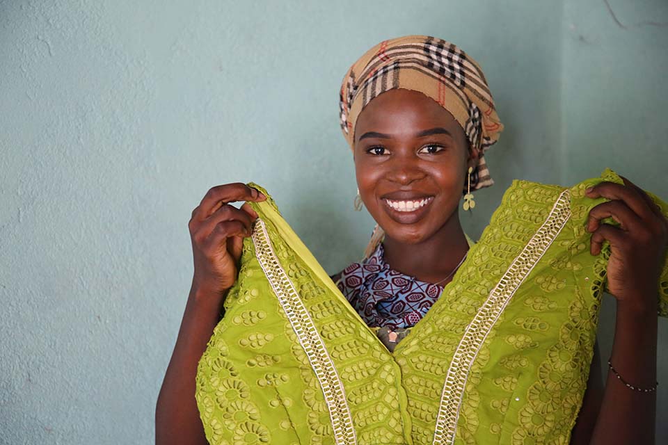 Cameroon woman holds up custom made dress