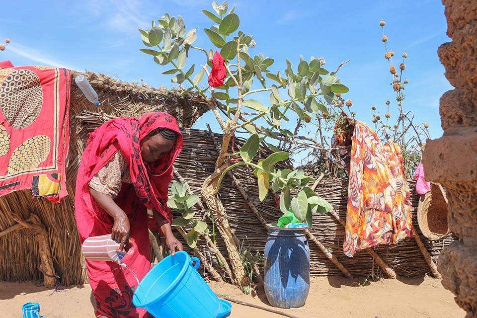 Sudanese refugee holding bucket