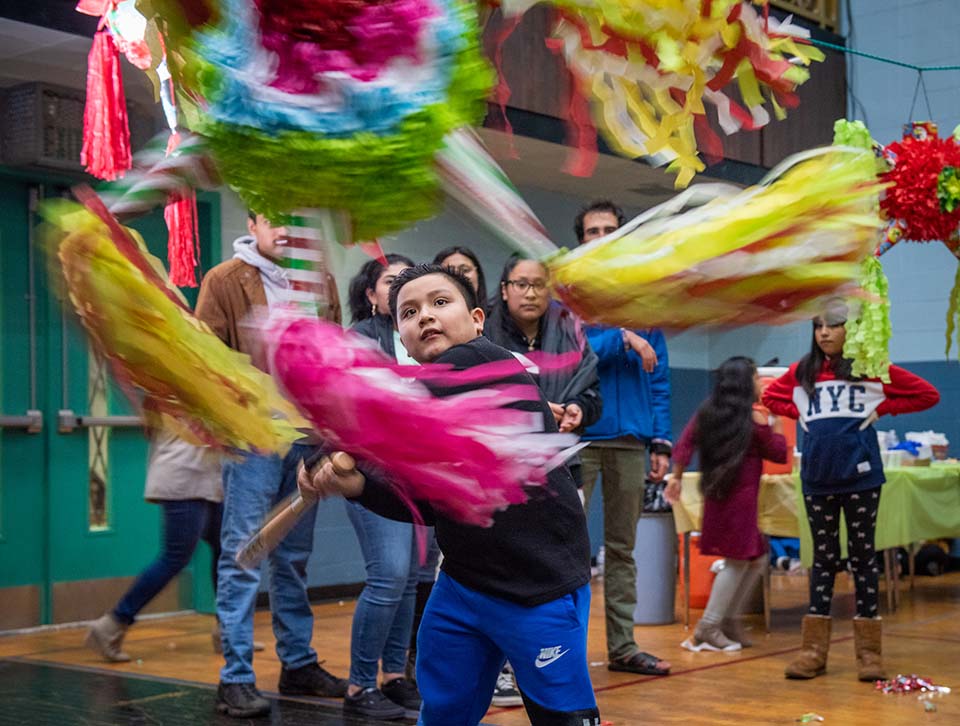 child swings at piñata