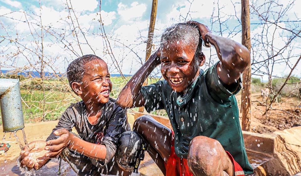 Children enjoy clean water from a pump in Ethiopia