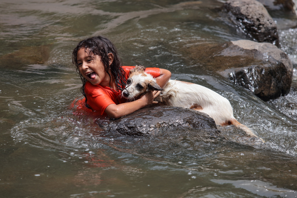 girls swims with dog in El Salvador