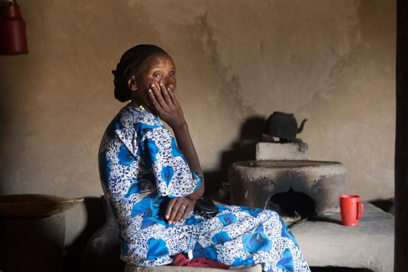 Photo by Sara A. Fajardo/CRS Ayuba Ahmed sits next to the fuel-efficient stove that helps her save 6 hours a day—time once dedicated to collecting firewood and preparing food. Photo by Sara A. Fajardo/CRS
