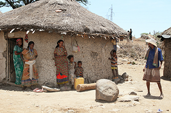 Jemal Bedhaso's wife and children seek shade outside their home. A CRS project is helping their village of Meiso cope with climate change. Photo by Kim Pozniak/CRS