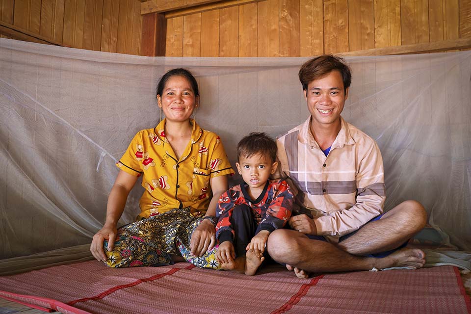 family sits together at home in Cambodia