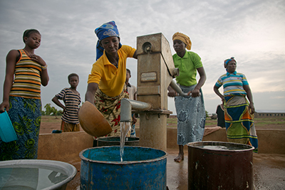 Women in Ghana collect water at a station constructed with support from CRS. Photo by Jim Stipe/CRS