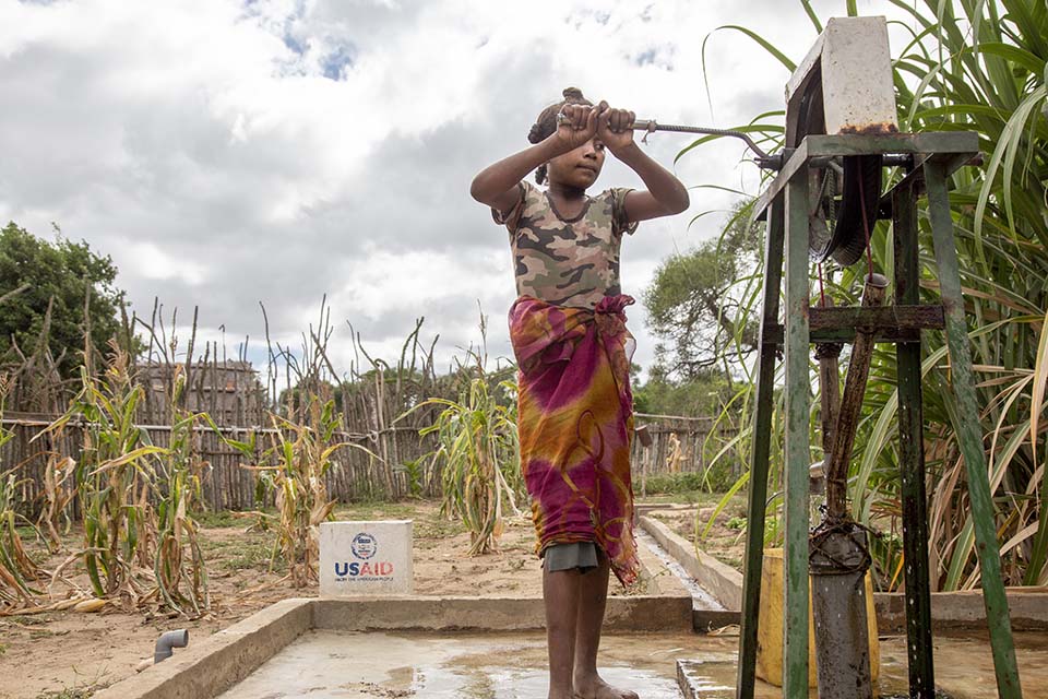 girl at water pump in Mozambique