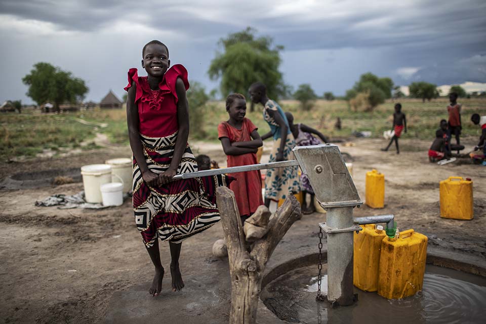 girls pump water at a well in South Sudan