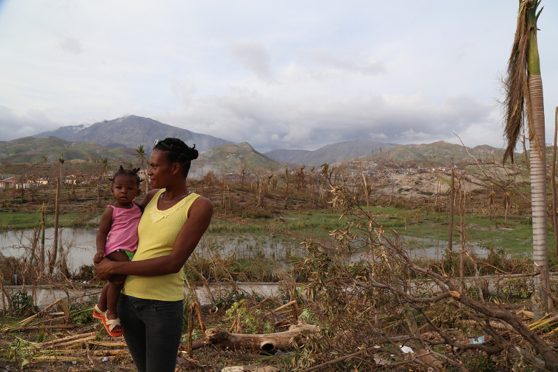 A woman named Celine holds her baby, looking toward where her home in Roche a Bateau stood. Roche a Bateau, a town roughly 30 miles southeast of Les Anglaise where the eye of Hurricane Matthew struck, has very few homes standing.