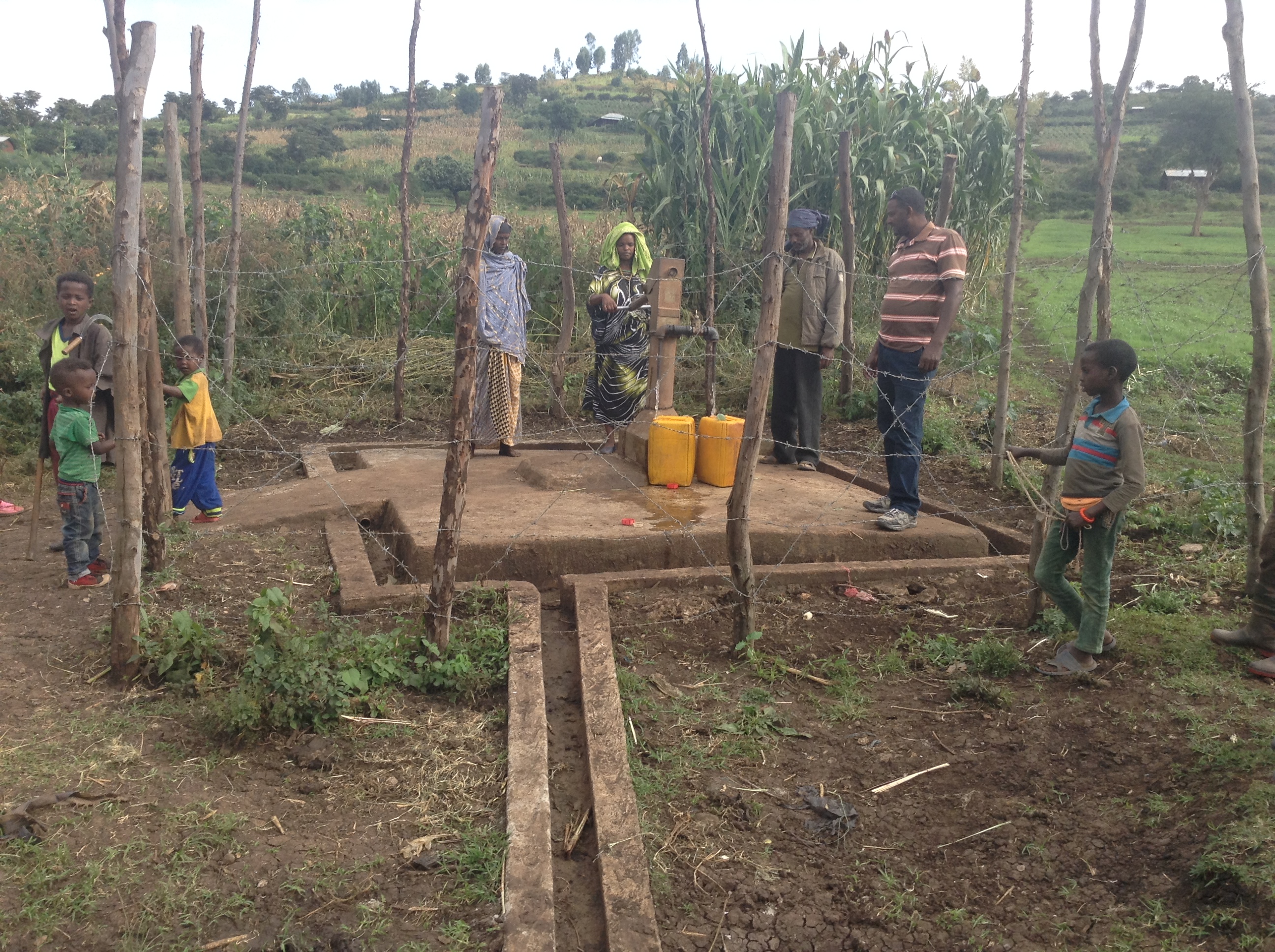 Community members examine their hand-dug well. Photo by Gutu Kenesa for CRS Community members examine their hand-dug well. Photo by Gutu Kenesa for CRS