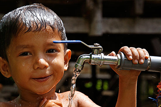 A young boy in Pulau Aceh, Indonesia, gets cleaned up at a tap provided by Catholic Relief Services. Photo by Sean Sprague for CRS