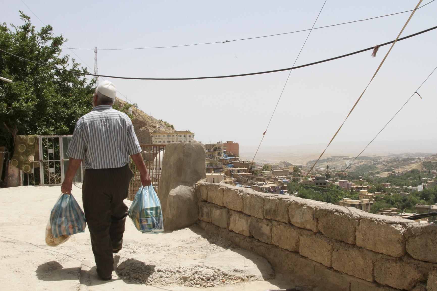 A few bags of groceries, purchased with vouchers from CRS, are a precious commodity for families like Salahaldin Yaseen's, who fled ISIS and have few options to earn money. Photo by Kim Pozniak/CRS