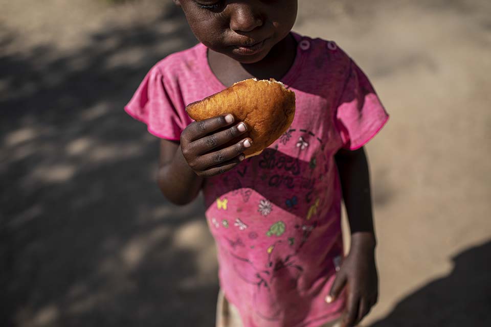 Kenya girl eats pastry called mandazi