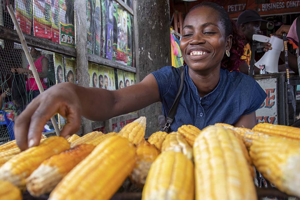 Liberian woman at market selling corn