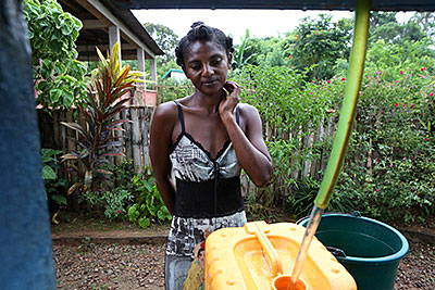 Ernestine Bothra collects water at one of two new washing stations in Anivorano Est, Madagascar. A public-private partnership is making clean water possible for her family. Photo by Sara A. Fajardo/CRS