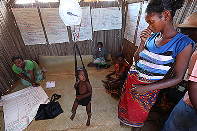 A health worker weighs children in Mahatsara, Madagascar, each month to monitor their growth. Photo by Sara A. Fajardo/CRS