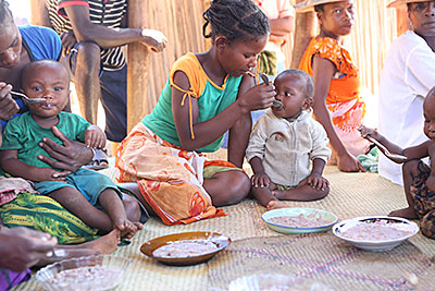 A mother in Madagascar feeds her daughter peanut stew. She learned to make it at a CRS-sponsored nutrition session during which children received 12 days of high-fat, high-protein food. Photo by Sara A. Fajardo/CRS