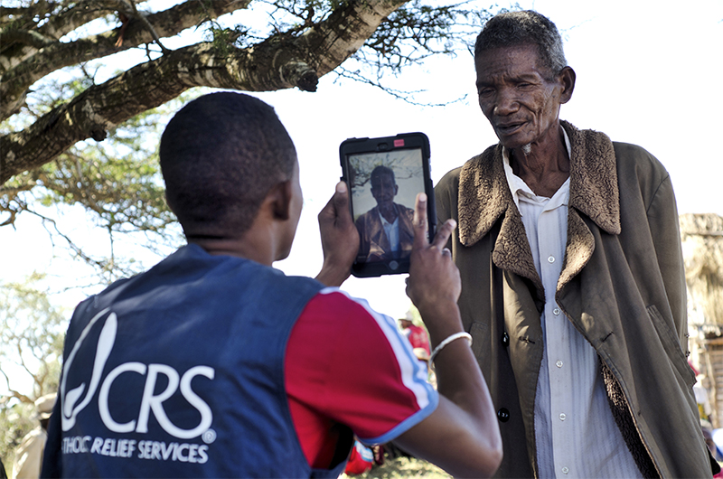 Photo by Heidi Yanulis for CRS CRS field staff register beneficiaries for programs using mobile devices.