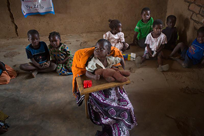 CRS helped provide Promisi a special chair so she can attend classes at the child care center in Nsanama Village, Malawi.