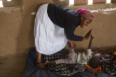 Loda Kachingwe, a volunteer teacher, plays with Promisi, who has become more responsive with therapy supported through a CRS program. Photo by Sara A. Fajardo/CRS