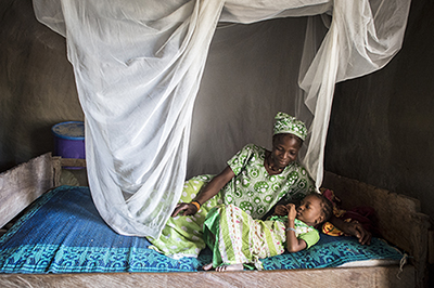 mother and child under malaria net