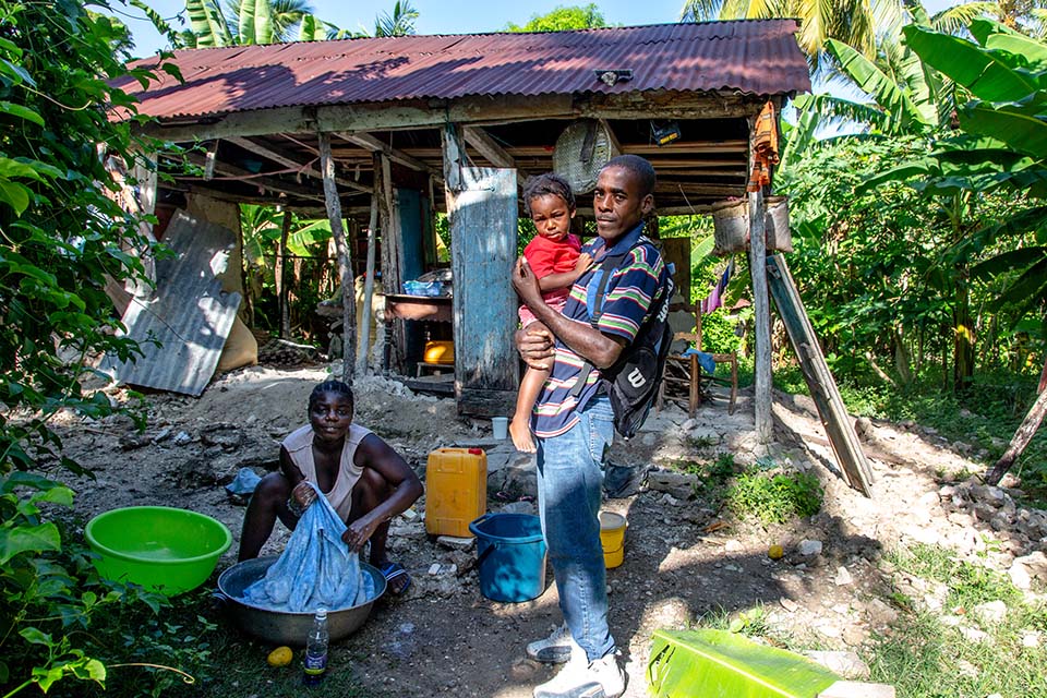 man holds child in Haiti