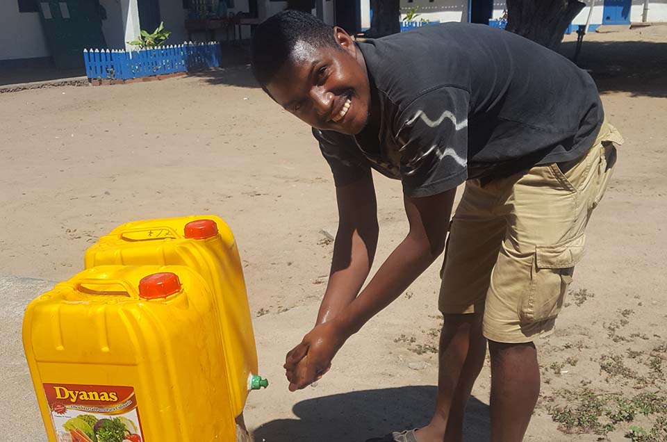 man washes his hands with water from a jerry can in Madagascar