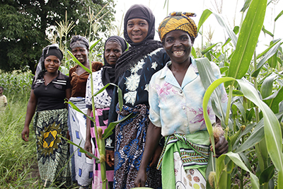 Agness, Annie, Mariam, Rose and Asiyatu farm together in a communal field in Malawi. Together they are reducing hunger and poverty in their village. Photo by Megan Collins for CRS