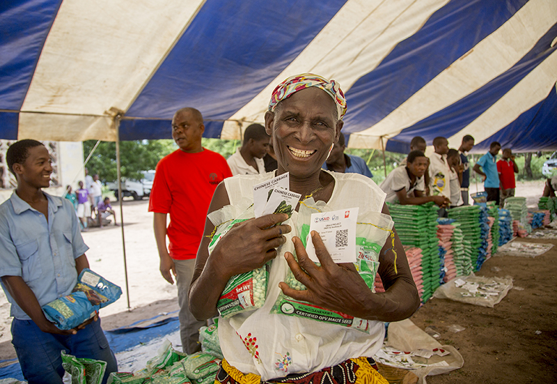 Photo by Georgina Goodwin for CRS Alefa Tom receives drought-resistant seeds at a CRS-supported seed fair in Malawi.