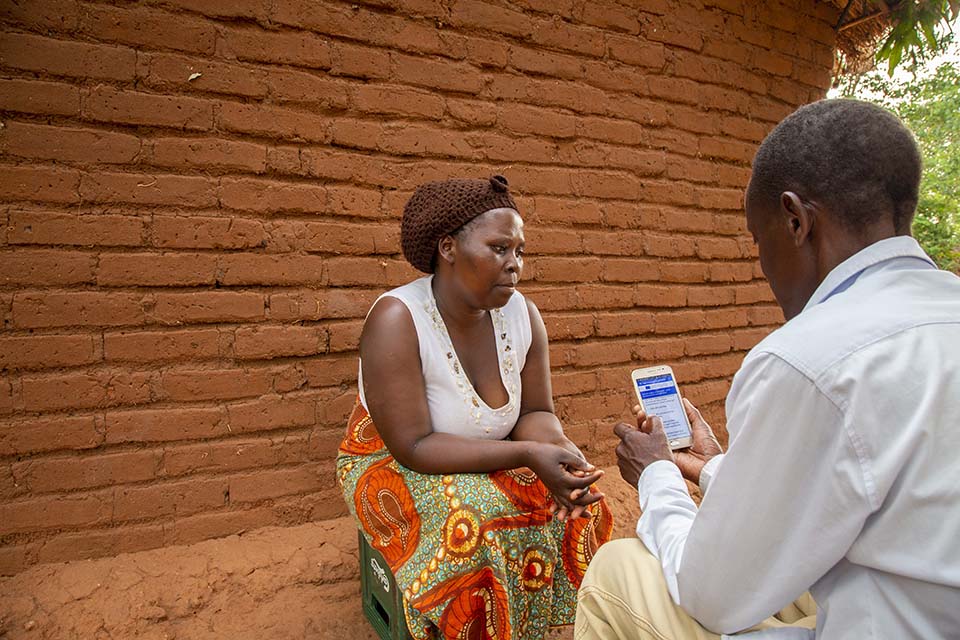 CRS MIRA enumerator interviews participant in Malawi