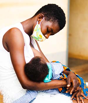 mother holding child in lap in Ghana