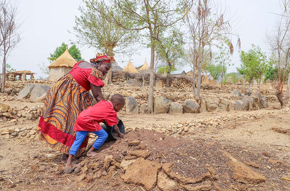 mother and son work farmland in Cameroon