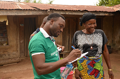 Segun Owoyermi, CRS program manager for the Sustainable Cassava Seed System project in Nigeria, works with Mwuese Jato, a farmer and a widow who heads a 14-member household. Photo by Michael Stulman/CRS