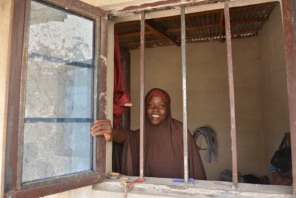 woman looks out window in Nigeria