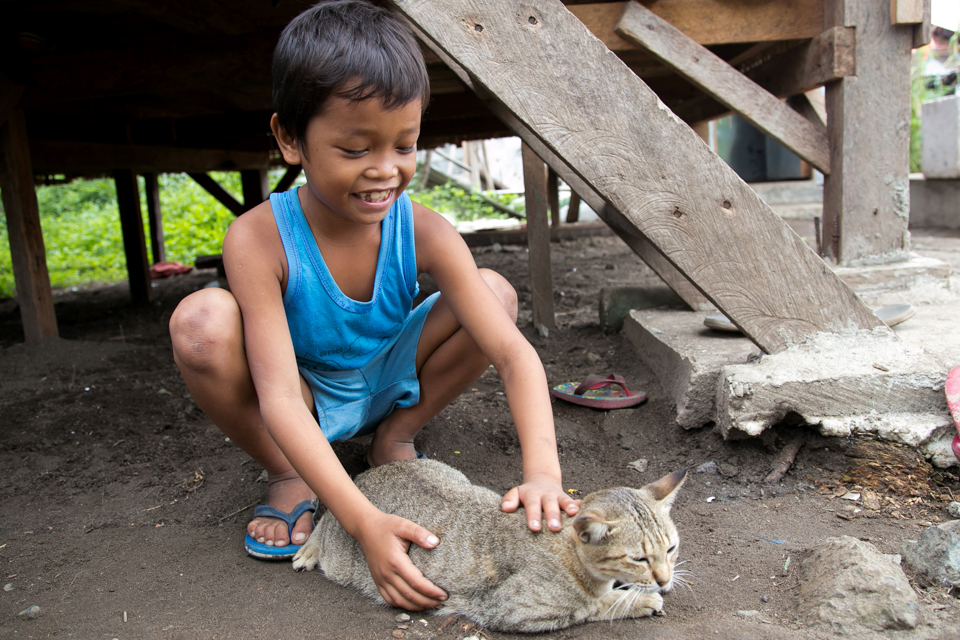 boy pets cat in the Philippines