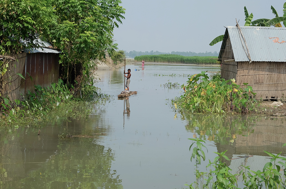 A boy moves through a flooded area of his village in Bangladesh.