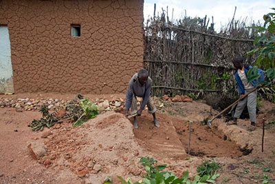 Dominique Mazimpaka and his son Innocent, 13, build a double-dug garden. Dominique learned how a double-dug garden can improve soil and preserve moisture through a project of Keurig Green Mountain and CRS. Photo by Laura Elizabeth Pohl