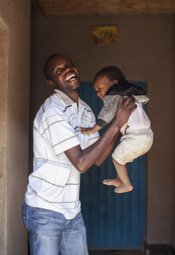 Deodate Nsengimana plays with daughter Olga at their home in Rwanda. Photo by Laura Elizabeth Pohl for CRS