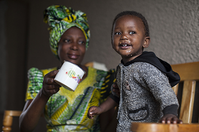 Odette Mukamurenzi, with daughter Olga, participates in a CRS program that teaches families how to grow and prepare nutritious food, and save money. Photo by Laura Elizabeth Pohl for CRS