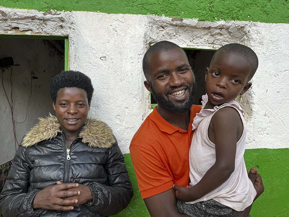 Rwanda barber and family outside his shop