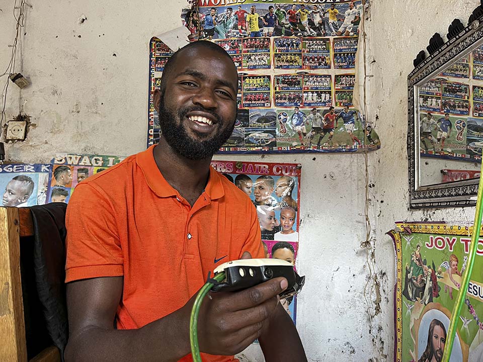 Rwanda barber holds shaver in this shop